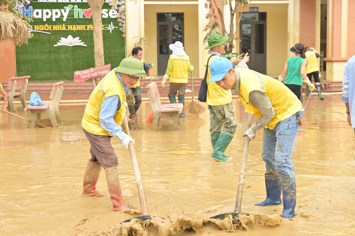 Tình nguyện viên CLB Gia Đình Hạnh Phúc dọn bùn tại trường học sau mưa lũ